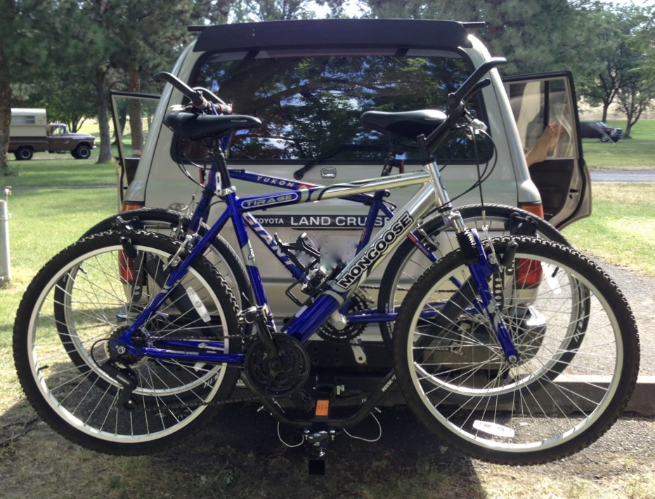 Two bikes mounted on rack.