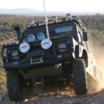 A Land Rover well fitted out with up to date and robust off road gear climbs a rise